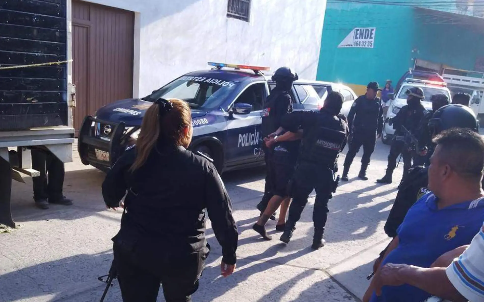 policias llevando a un detenido